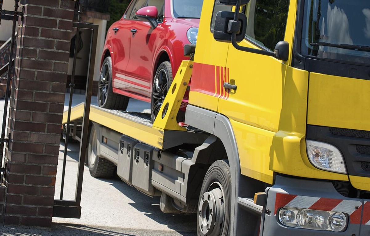 Professional emergency towing service with flatbed truck loading a vehicle in Arlington Heights, IL