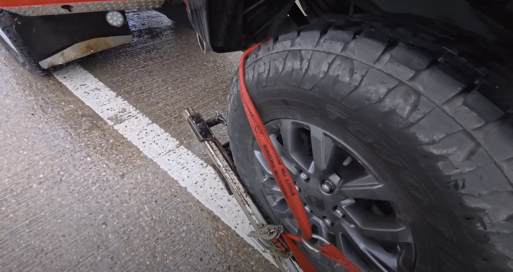 Vehicle Protection - Secure towing with proper safety equipment Professional towing service securing vehicle with safety straps